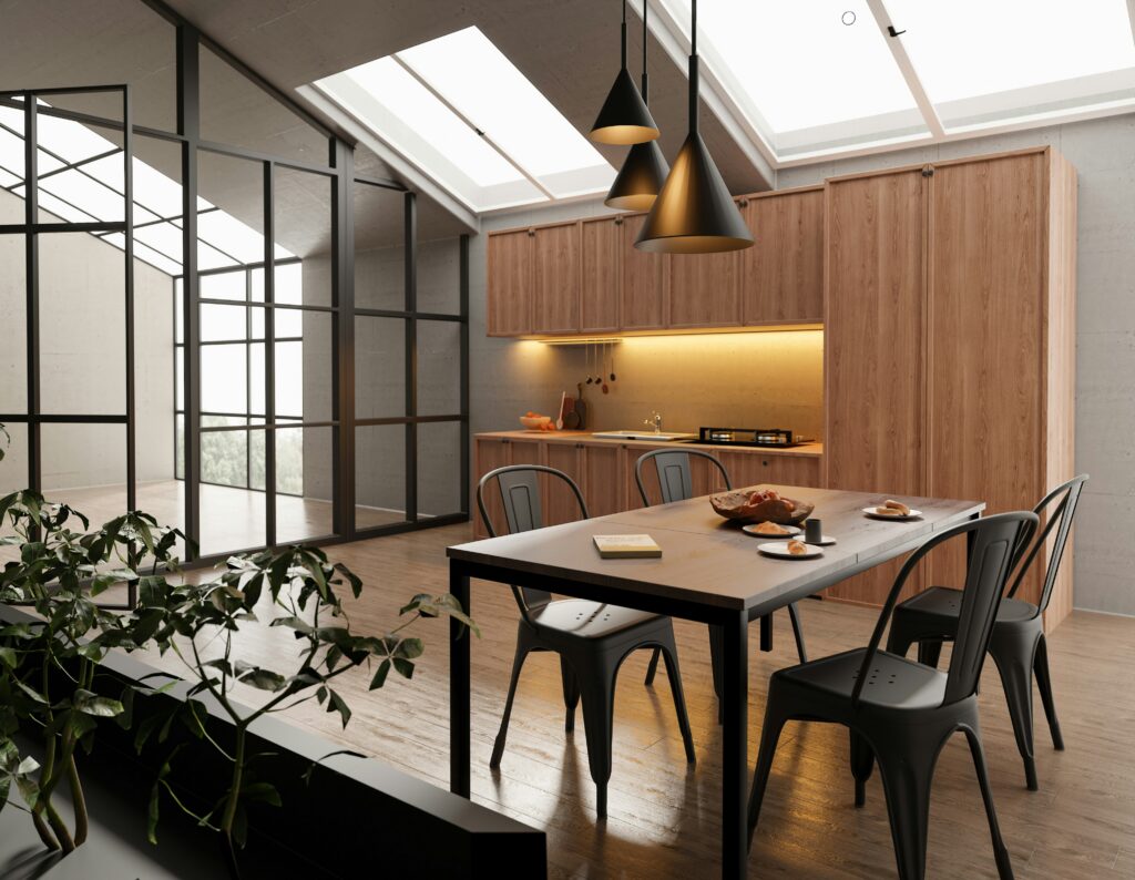 Cuisine et salle à manger modernes sous verrière avec chaises métalliques noires et meubles en bois.